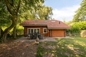 a small house with a table and chairs in a yard at Luxe, rust en ruimte bij de Veluwse Vijf in Epe in Epe