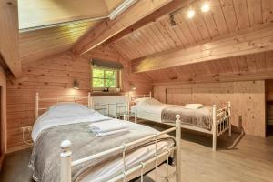 a bedroom with two beds in a log cabin at Luxe, rust en ruimte bij de Veluwse Vijf in Epe in Epe