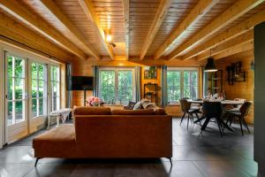 a living room with a couch and a table at Luxe, rust en ruimte bij de Veluwse Vijf in Epe in Epe