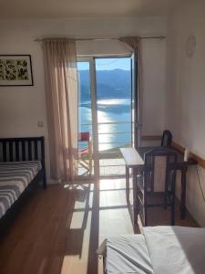 a bedroom with a balcony with a view of the ocean at Vila Arena in Mandići