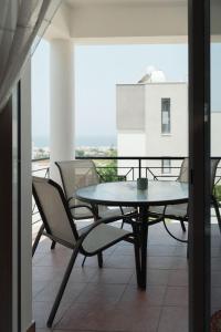 a table and chairs on a balcony with a view at Chloraka Sea View Apt with Pool in Khlorakas