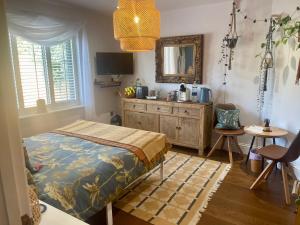 a bedroom with a bed and a dresser and a mirror at The Bloom-Room in Stratford-upon-Avon +9 photos