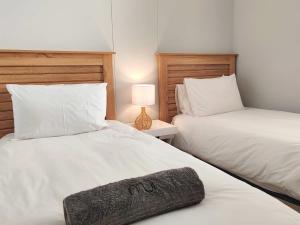 two beds sitting next to each other in a bedroom at Waveside Stays in Muizenberg