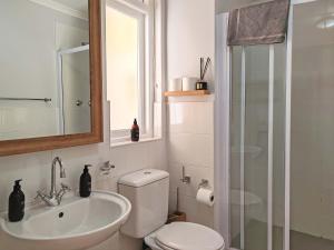 a bathroom with a toilet and a sink and a shower at Waveside Stays in Muizenberg +37 photos