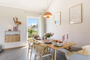 a dining room with a table with food on it at Feldkoje - Luxuriöses Design-Ferienhaus mit Kamin und Feldrandlage in Fehmarn +45 photos