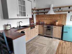 a kitchen with white cabinets and a wooden floor at Nie Samym Chlebem in Poborszów