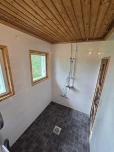 a room with a tile floor and a wooden ceiling at Revontulet ZH Tulimetsän Kylä in Pieksämäki +51 photos