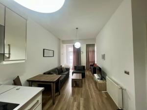 a living room with a couch and a table at Apartment in green Budapest in Tbilisi City