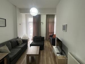 a living room with a couch and a tv at Apartment in green Budapest in Tbilisi City