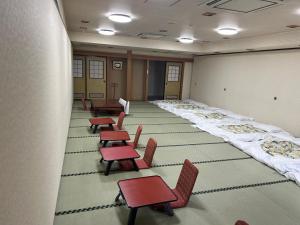 ein Raum mit Reihen von Stühlen und Tischen in einem Klassenzimmer in der Unterkunft RB HOTEL Dakeonsen in Nihommatsu