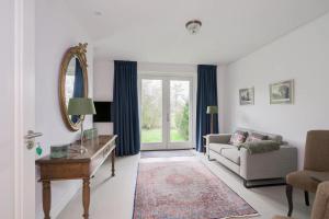 a living room with a couch and a mirror at Bij Oriënshuis in Varsseveld
