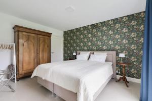 a bedroom with a large bed with floral wallpaper at Bij Oriënshuis in Varsseveld
