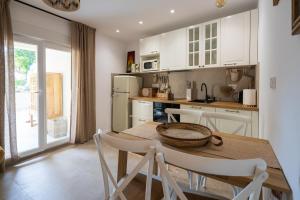 a kitchen with white cabinets and a table and chairs at Tembo Apartment in Sinj