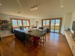 a kitchen and living room with a table and chairs at 3 bedroom Modern Alpine Escape in Chateau-d'Oex