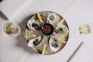 a plate of oysters on a table with wine glasses at Landgoed Altenbroek in Voeren