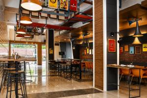 ein Restaurant mit Tischen und Stühlen in einem Raum in der Unterkunft Max Hotels Jabalpur in Jabalpur