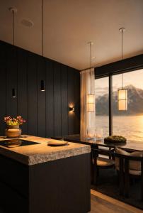a kitchen with a island and a dining room with a view at Fredvang Lodge, Lofoten in Fredvang