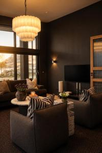 a living room with couches and a chandelier at Fredvang Lodge, Lofoten in Fredvang