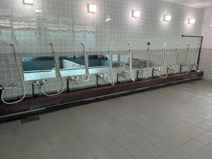 a row of stalls in a bathroom with mirrors at RB hotel in Aizuwakamatsu