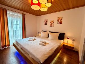 a bedroom with a large bed with two towels on it at Bergbauernhof Leitenlehen in Berchtesgaden