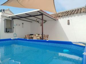 a swimming pool with an umbrella next to a house at Casa de Tina y Cora in Mora