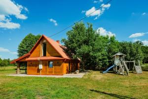 a small house with a slide in a field at Stachowa Chata Guciów in Guciów
