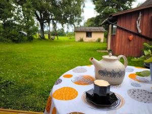 a table with a tea pot and hats on it at Barn Suite in Valga