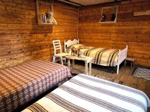 a bedroom with two beds and a table and chairs at Barn Suite in Valga