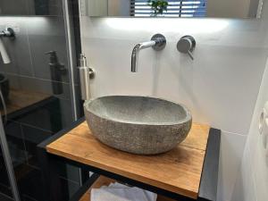 een badkamer met een stenen wastafel op een houten tafel bij Luxe Tiny House Ooij in Ooij