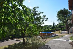 a yard with a tree and a swimming pool at Le Gîte des Petits Cailloux in Vellechevreux-et-Courbenans