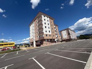 an empty parking lot with two tall buildings at Apartman Daniela Lake View in Donje Mladice