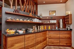 a kitchen with wooden cabinets and a counter top at WAGNERS Hotel im Bayerischen Wald in Grafenau