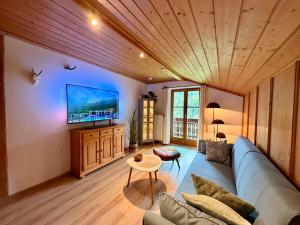 a living room with a couch and a tv at Bergbauernhof Leitenlehen in Berchtesgaden