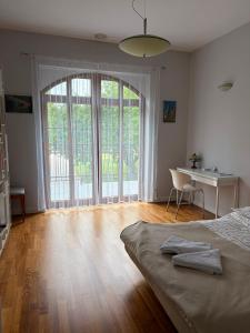 a bedroom with a bed and a desk and a large window at Dwór Grabina in Ciechomice