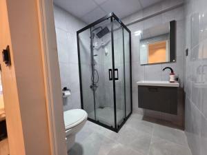 a bathroom with a shower and a toilet and a sink at Ada Park Hotel in Kuşadası +87 photos