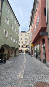 a cobblestone street in a city with buildings at Brück Residenz - 100qm Altstadtwohnung an der Steinernen Brücke in Regensburg