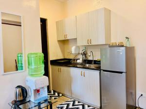 a small kitchen with a refrigerator and a mixer at Haku Haven in Baguio