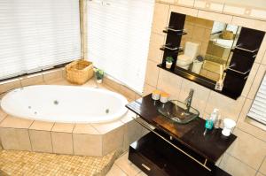 a large bathroom with a tub and a sink at The Sanctuary- Self Catering Accommodation in Nelspruit +34 photos