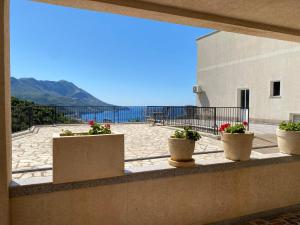 a balcony with potted plants and a view of the ocean at Apartmani Ličina in Bečići