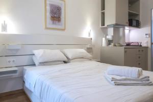 a bedroom with a white bed with towels on it at Syntagma Gem 1 in Athens