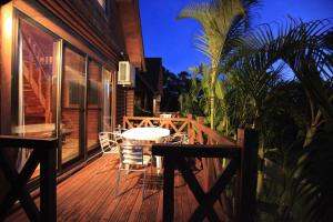 a wooden deck with a table and chairs on a house at Tokashiki Guest House in Tokashiki