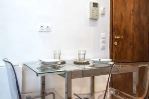 a glass table with two bowls and glasses on it at Syntagma Gem 1 in Athens