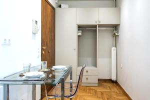 a dining room with a glass table and white cabinets at Syntagma Gem 1 in Athens +18 photos