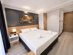 a bedroom with a large white bed with white pillows at Ada Park Hotel in Kuşadası