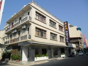 un edificio blanco con un cartel en el costado en New KM Hotel en Jincheng