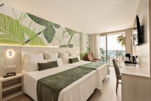 a hotel room with a large bed and a balcony at Hotel Best Maritim in Cambrils