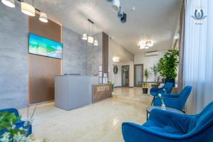 a lobby with blue chairs and a reception desk at Daria Boutique Hotel in Eforie Sud