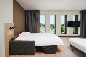 a hotel room with a large bed and a large window at Première Classe Warsaw Airport in Warsaw