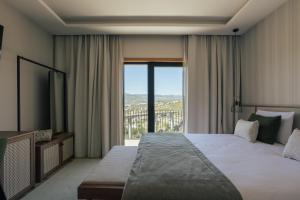 a bedroom with a large bed and a large window at Quinta do Roso - Douro Wine Estate - by FERO in Lamego +81 photos