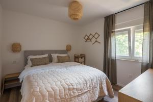 ein Schlafzimmer mit einem großen Bett und einem Fenster in der Unterkunft Mamba Apartment in Sinj